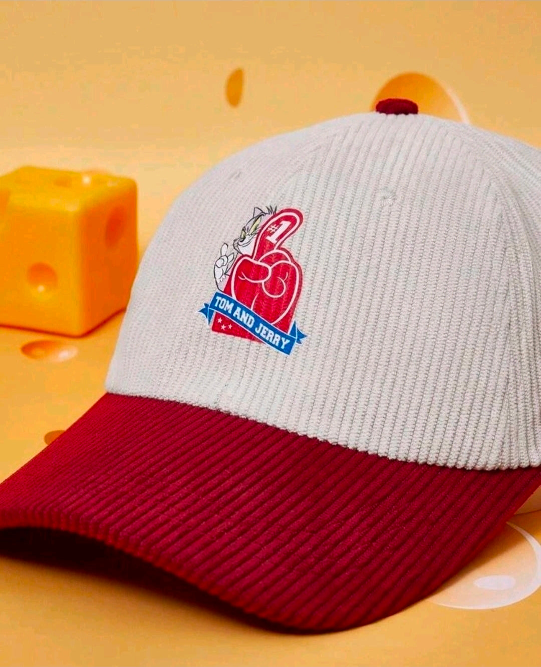 Two-tone baseball cap with light gray crown, burgundy brim, Tom & Jerry logo