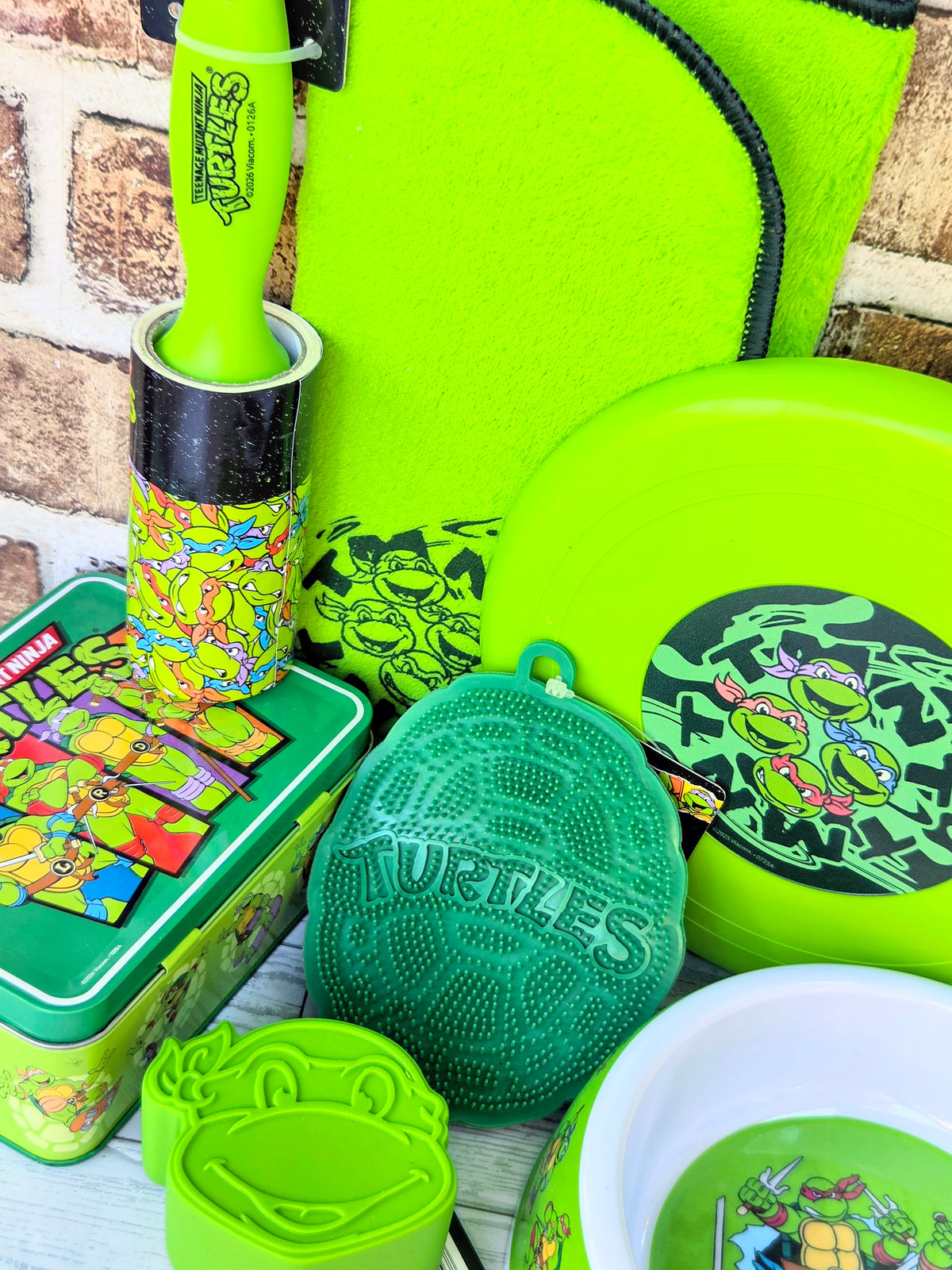 TMNT pet bowl, neon green frisbee, textured lint brush, and square tin accessory set