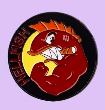 Close-up round enamel pin of red cartoon character face with yellow flames, black outline
