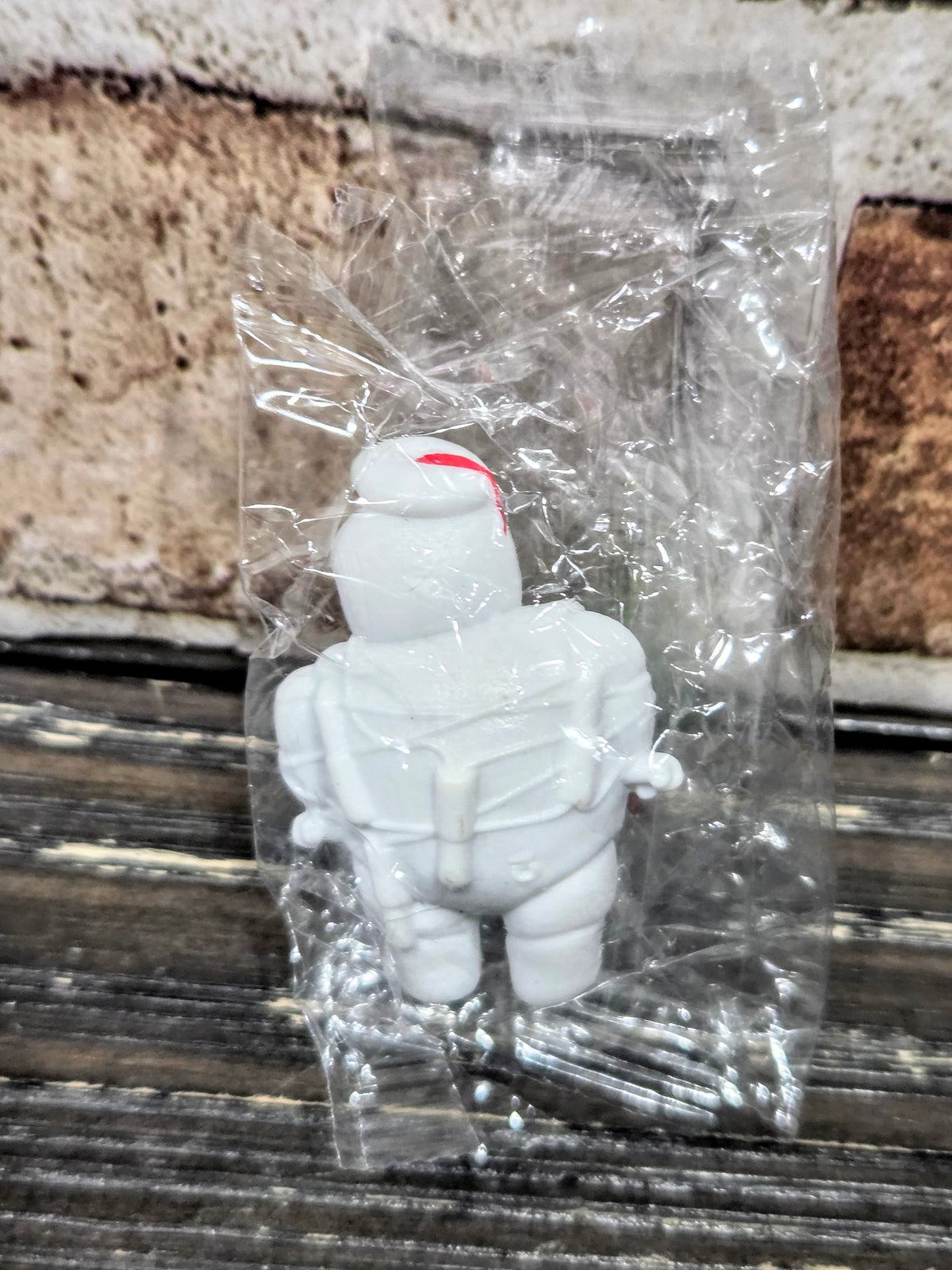 White Mini-Puft ghost figure with red and blue hat detail, in clear plastic bag