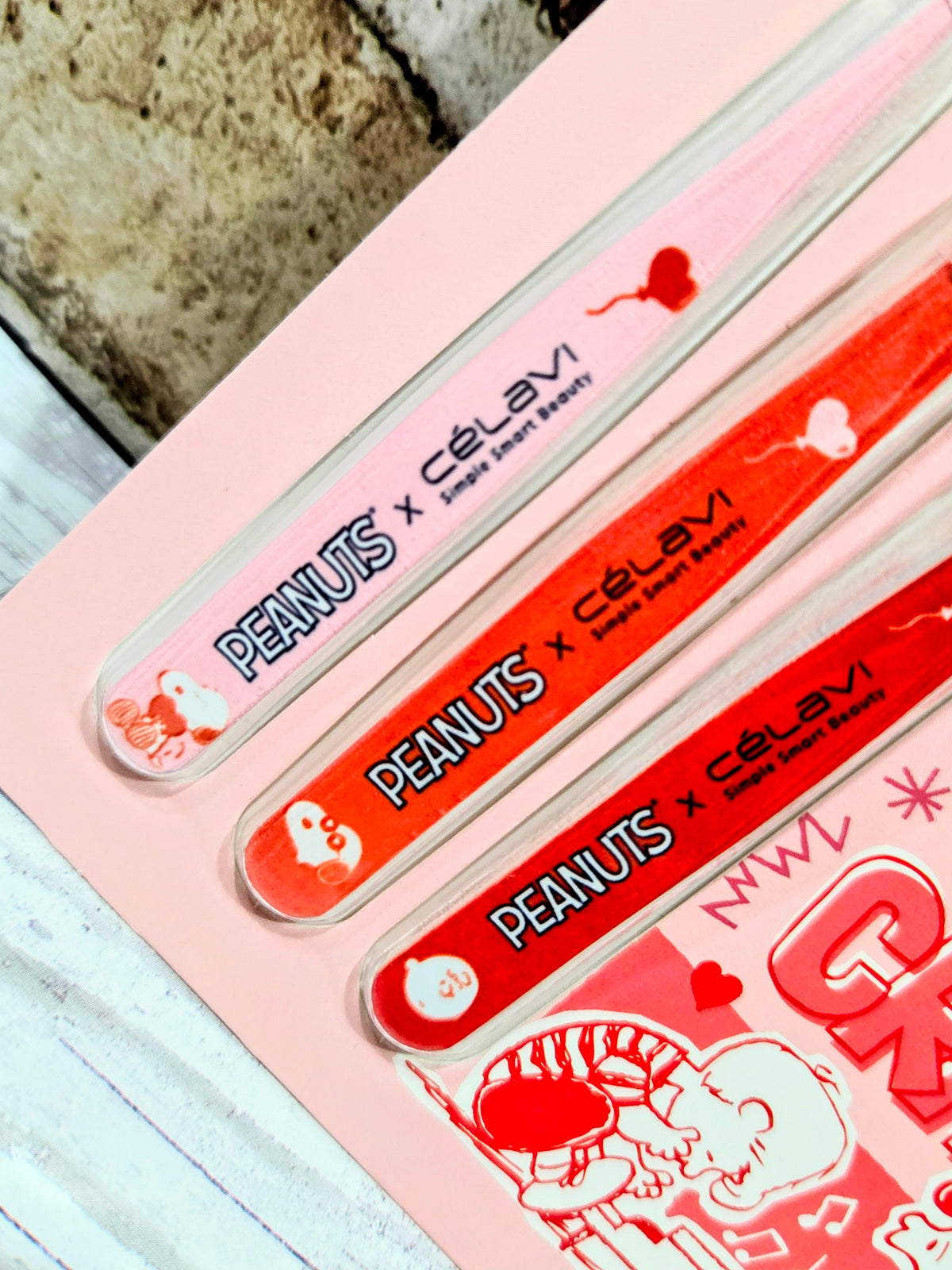 Close-up of red and clear Snoopy-themed tweezers in pink blister tray