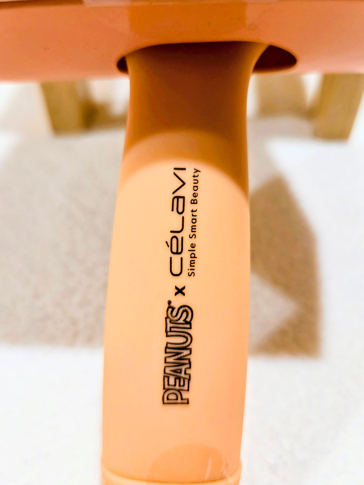Peanuts x Celavi charmed hair brush handle in orange with vertical logo text