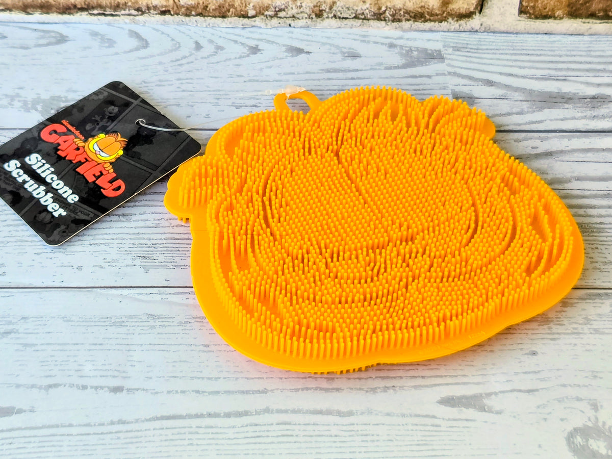 Orange lint roller brush pad with Garfield tag on clear backing