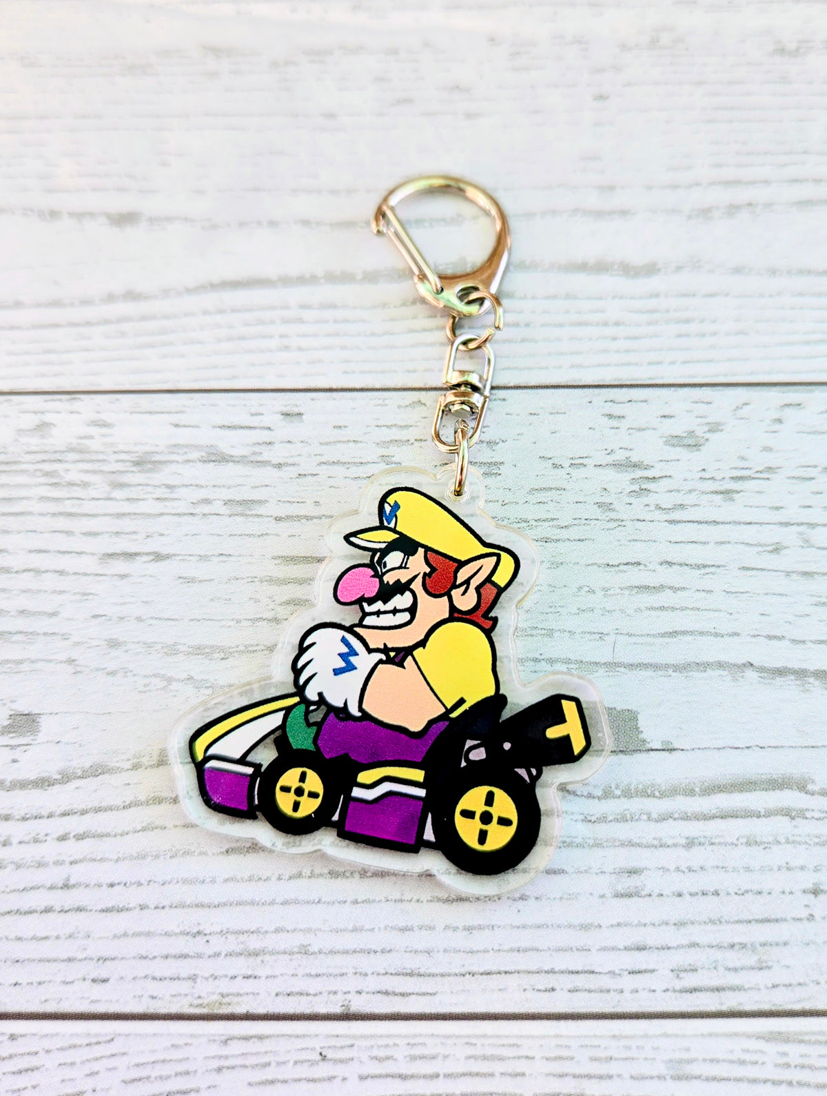 Wario acrylic keychain charm in a purple racing kart, die-cut outline