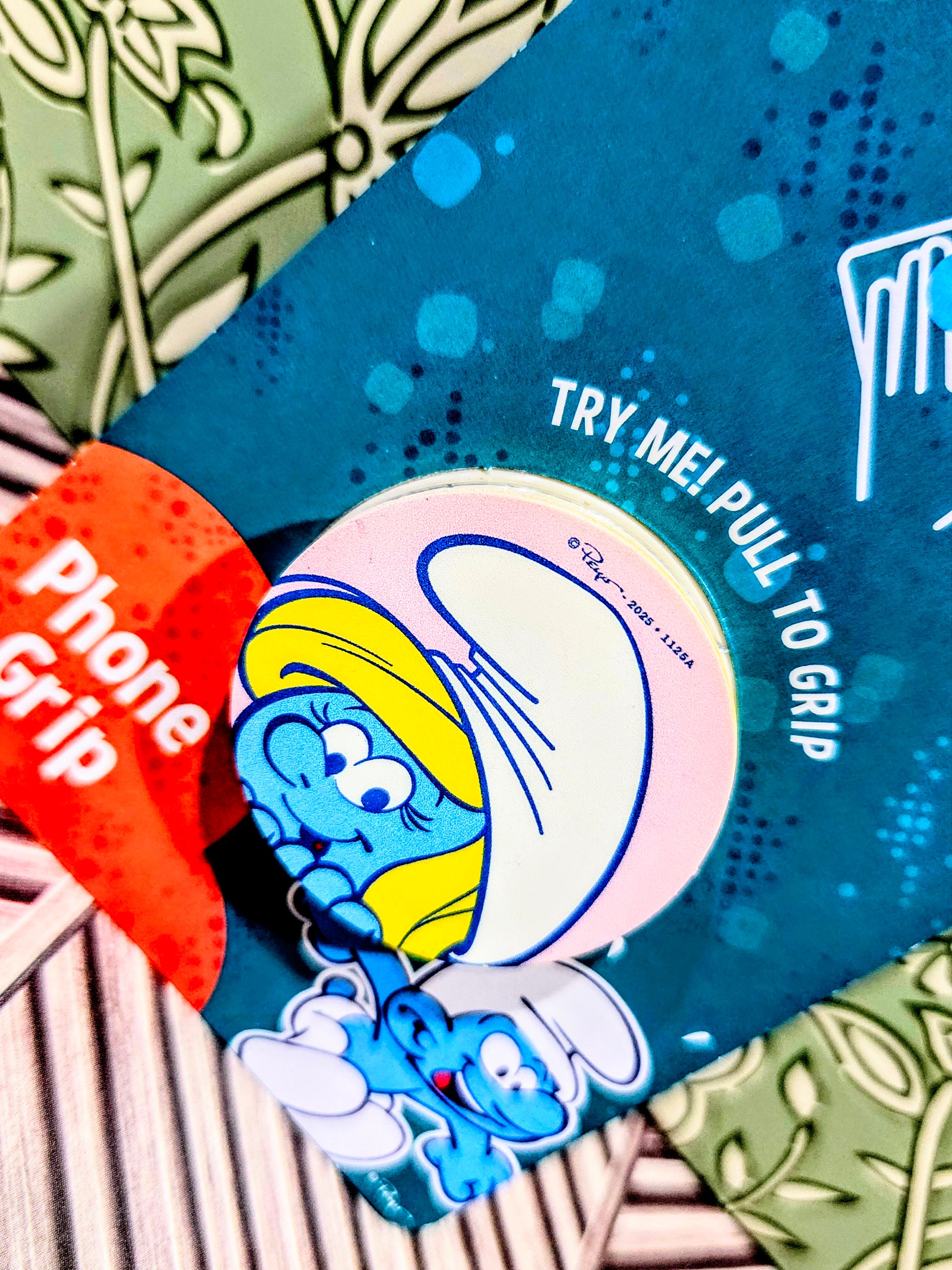 Smurf phone grip holder close-up with Try Me Pull to Grip text and character art