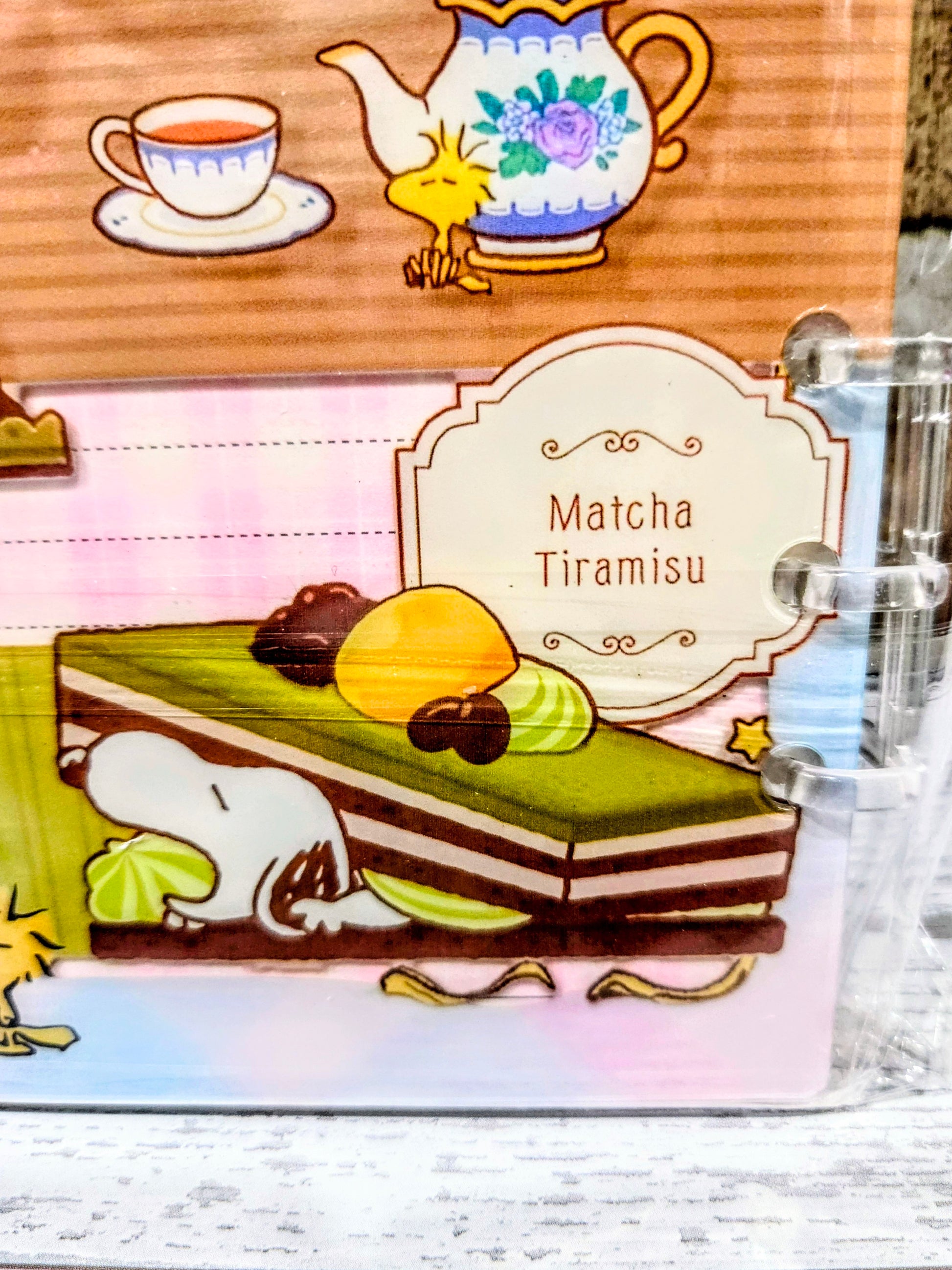 Close-up A5 acrylic shaker notebook page with Matcha Tiramisu illustration and food-themed graphics.