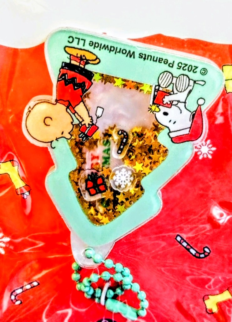 Snoopy keychain charm with beaded strand on a red blister card.