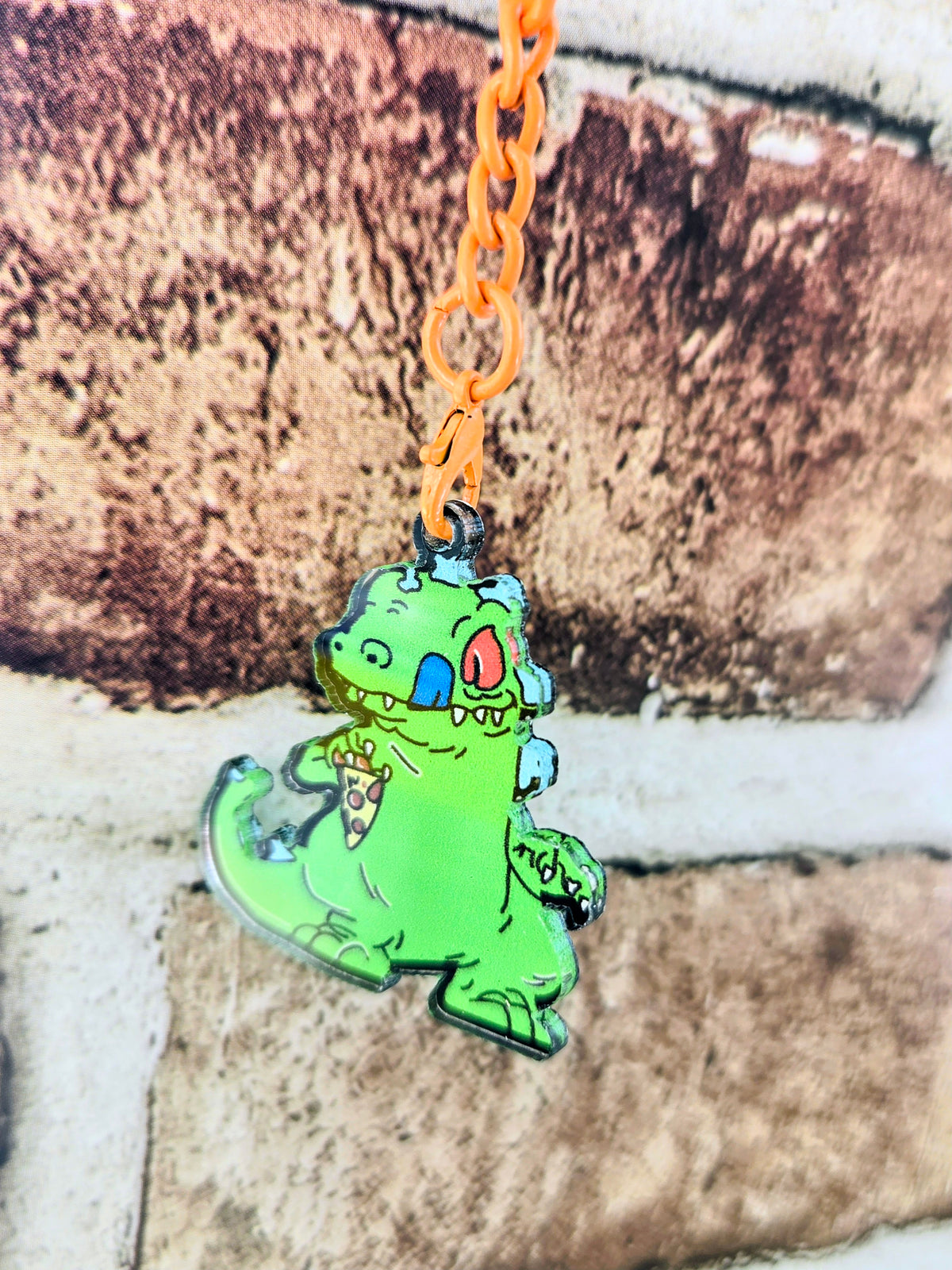 Orange-ring acrylic keychain with green Reptar character on an orange chain