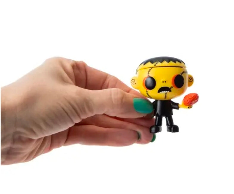 Chibi vinyl Halloween figure, yellow stitched face, black outfit, orange-red pumpkin accessory