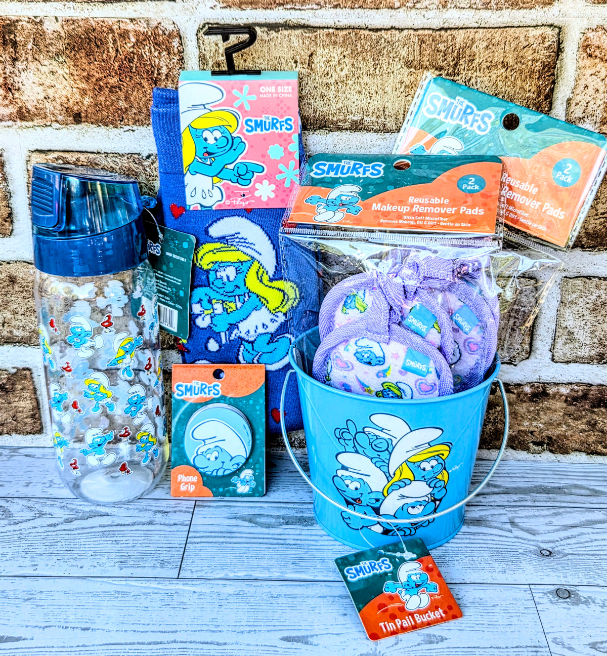 Smurfs self-care gift set with water bottle, blue socks, phone accessory, and pads