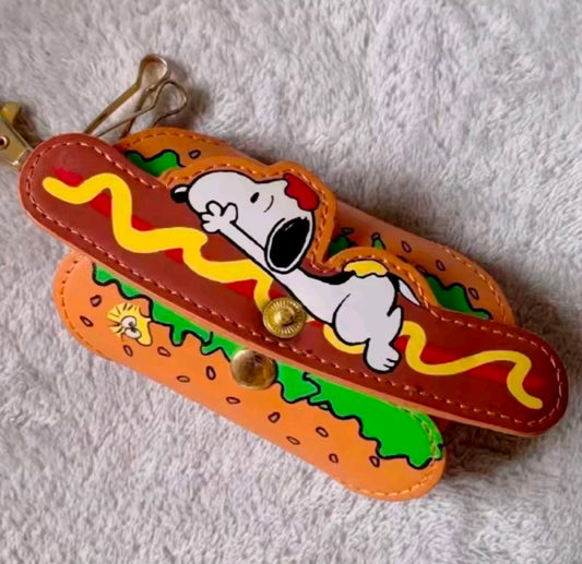 Hot dog keychain holder with Snoopy art, orange strap, green filling, and gold clasp