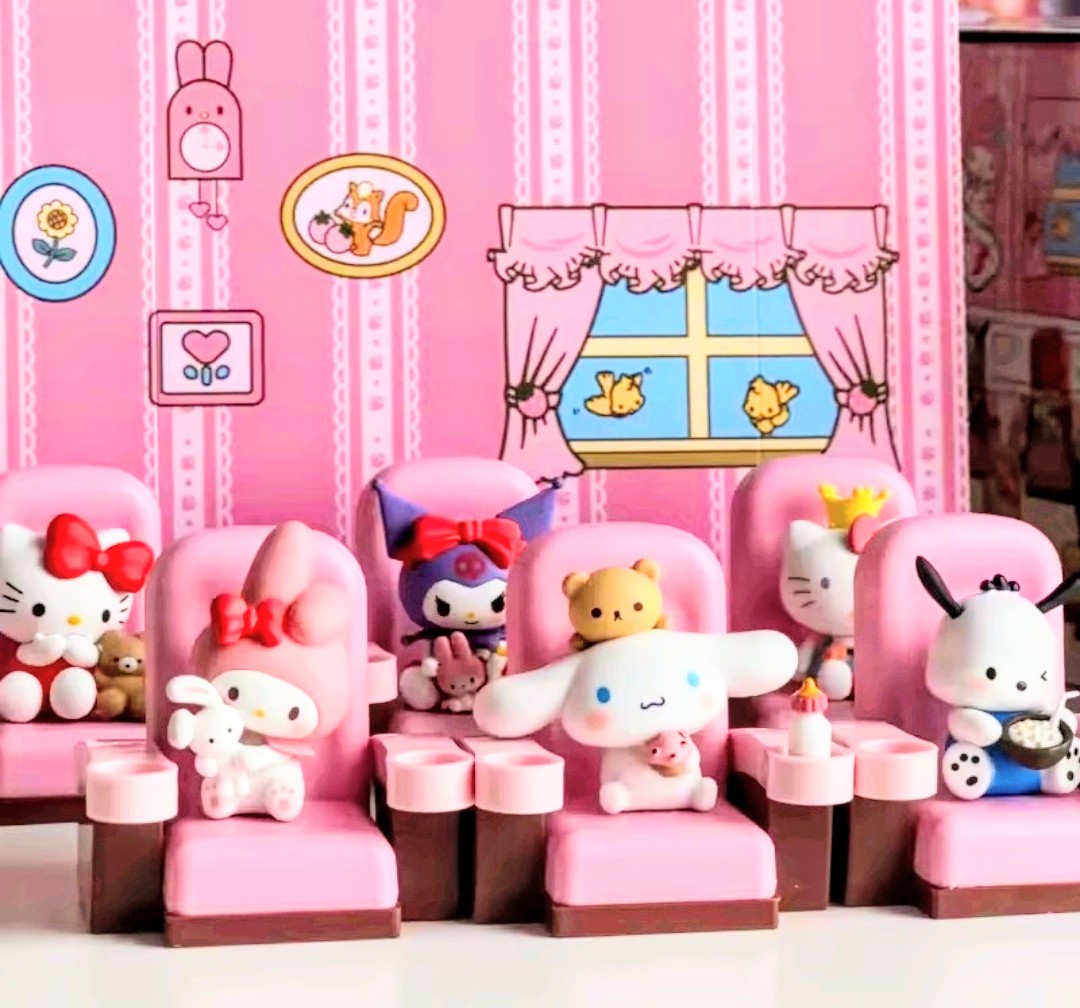 Mini character figures displayed in pink chairs inside a movie theater set