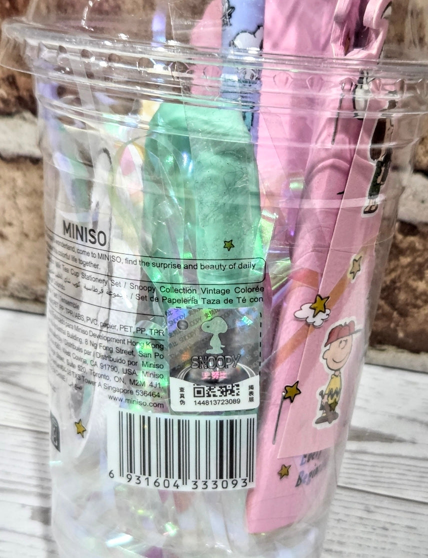 Transparent Snoopy stationery cup set packaging with MINISO label, barcode, and printed instructions.