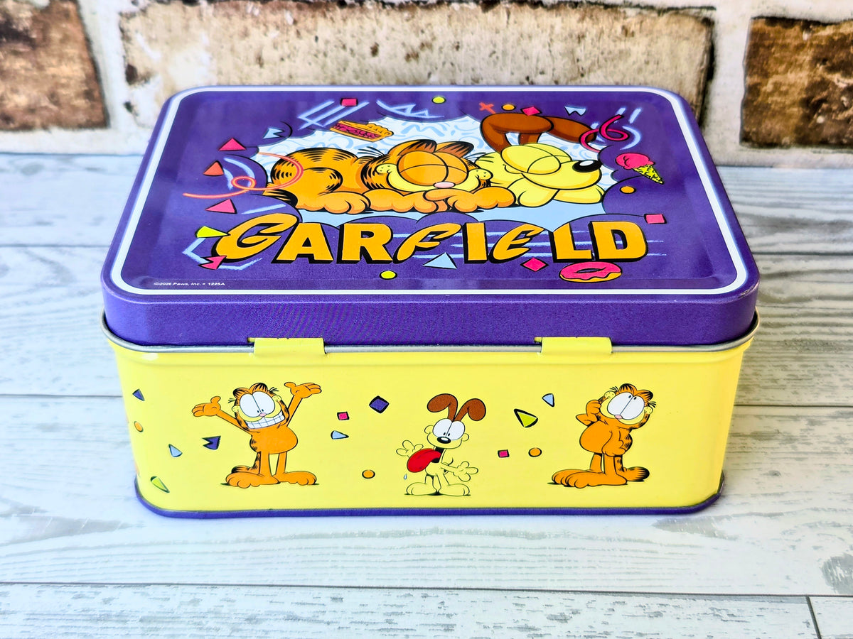 Garfield storage tin with blue lid and character graphics on light yellow body