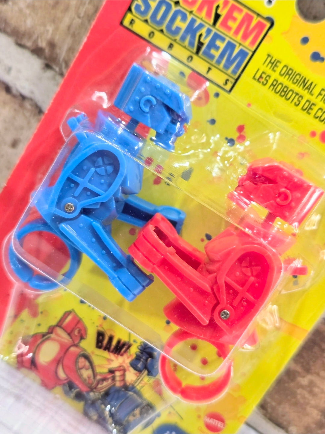 Angled close-up of robot finger rings in blue and red blister pack