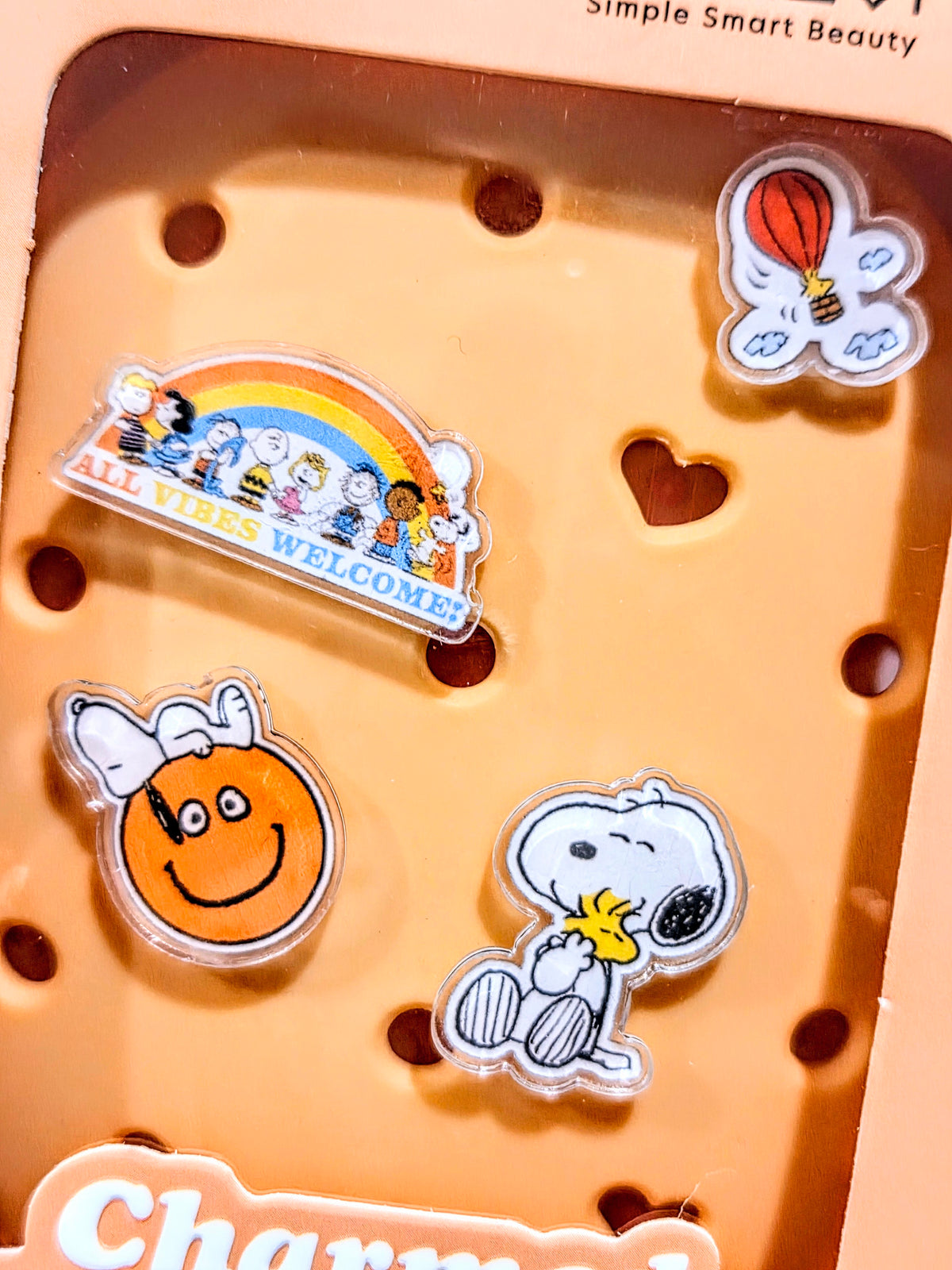 Orange brush charm display tray showing four acrylic charms inside the holder