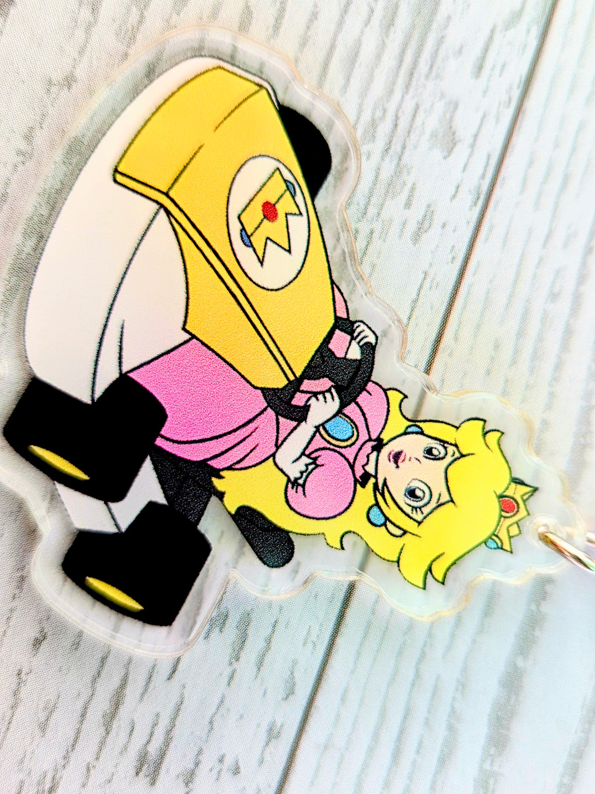 Acrylic die-cut keychain featuring Princess Peach with Toad in a racing kart