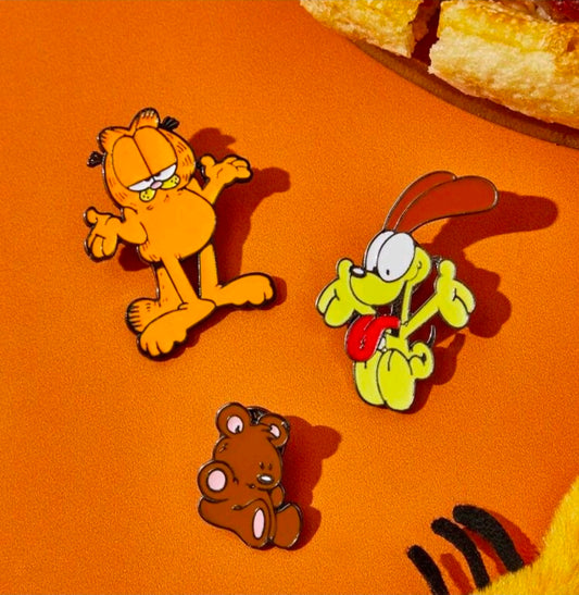 Three enamel character pins: yellow dog, orange cat, brown bear with metal posts