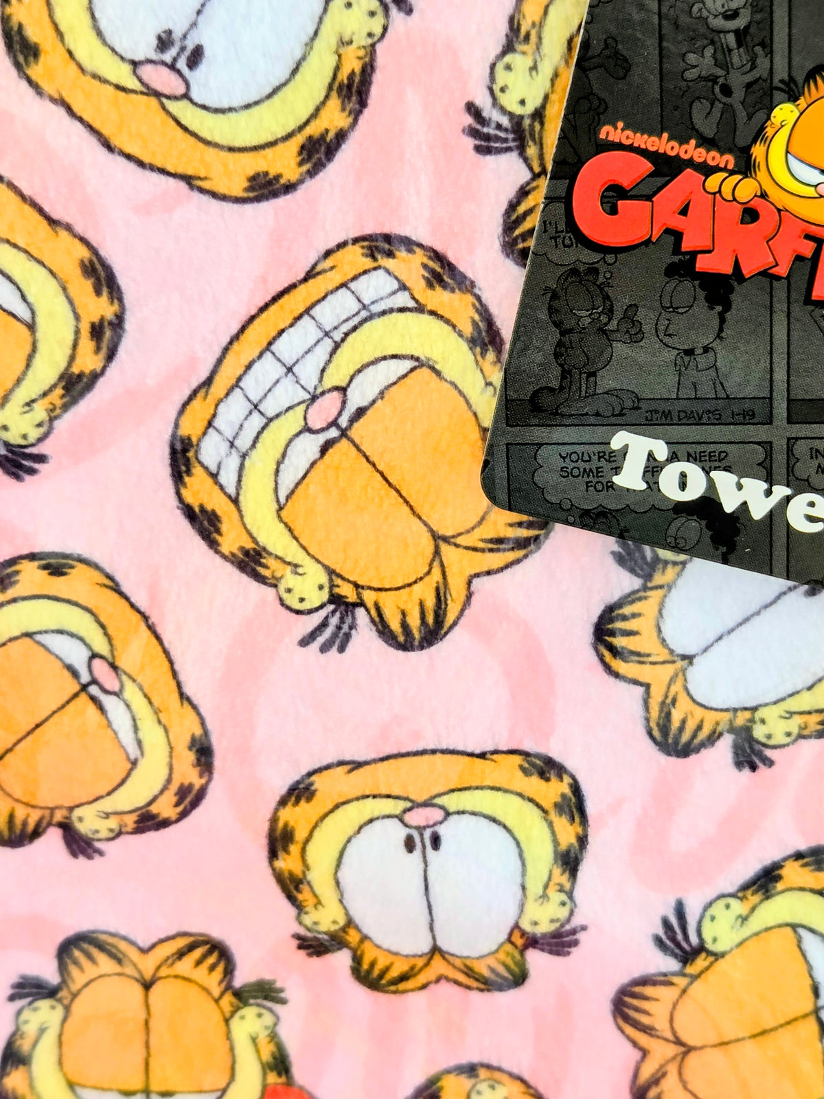 Pink plush fabric with repeating Garfield and Odie character print pattern