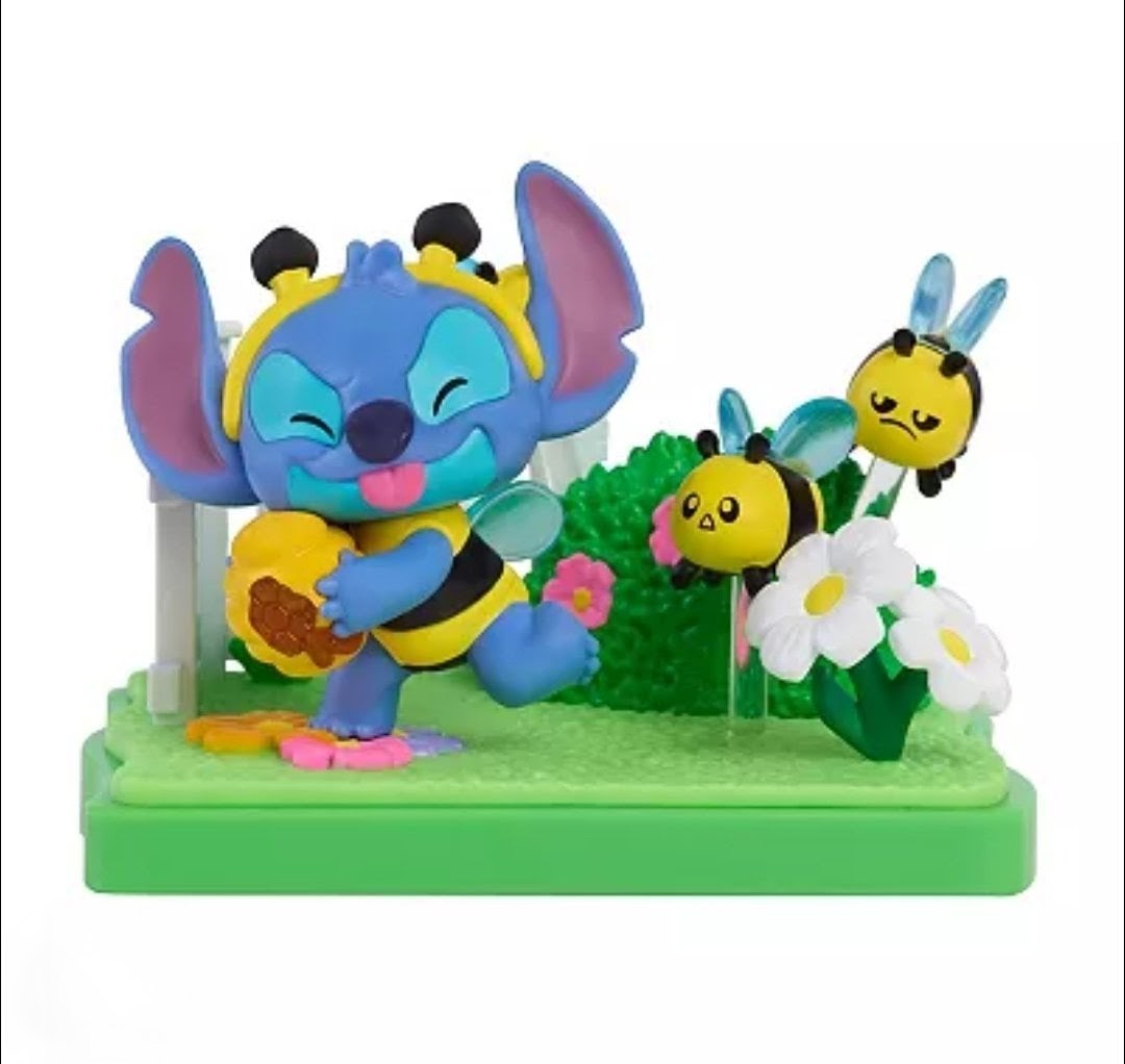 Stitch blind box figure in blue with yellow bee-like character and white flower on green base