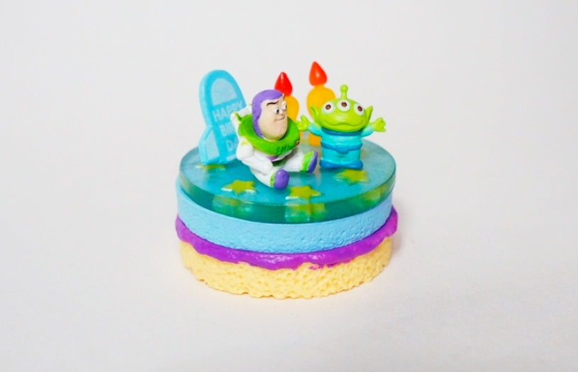 Mini cake figure with Buzz and green alien sitting on blue-green top