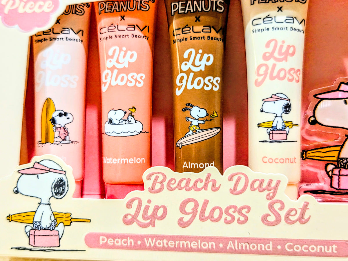 Four Beach Day lip gloss tubes in a box featuring Snoopy and surfing artwork