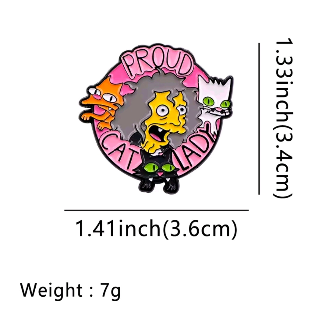 Round enamel pin with yellow character face, three cats, and “PROUD CAT LADY” text