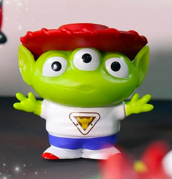 Green alien mini figure with red cap and white shirt, big googly eyes, front view