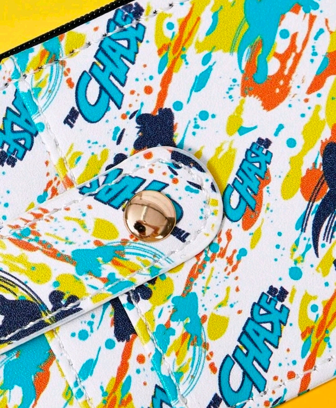 Paint-splash printed wallet close-up showing round keyring snap and fabric texture