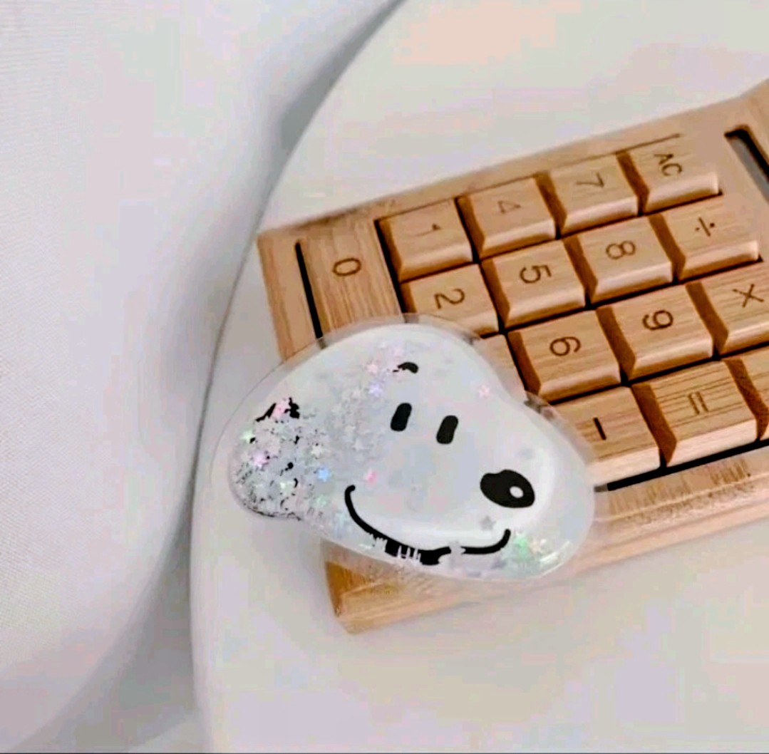 Heart-shaped Snoopy phone grip with glitter fill and black face details