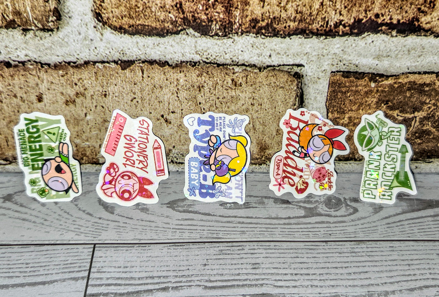 Holographic glitter sticker set with green energy and character designs on wooden boards