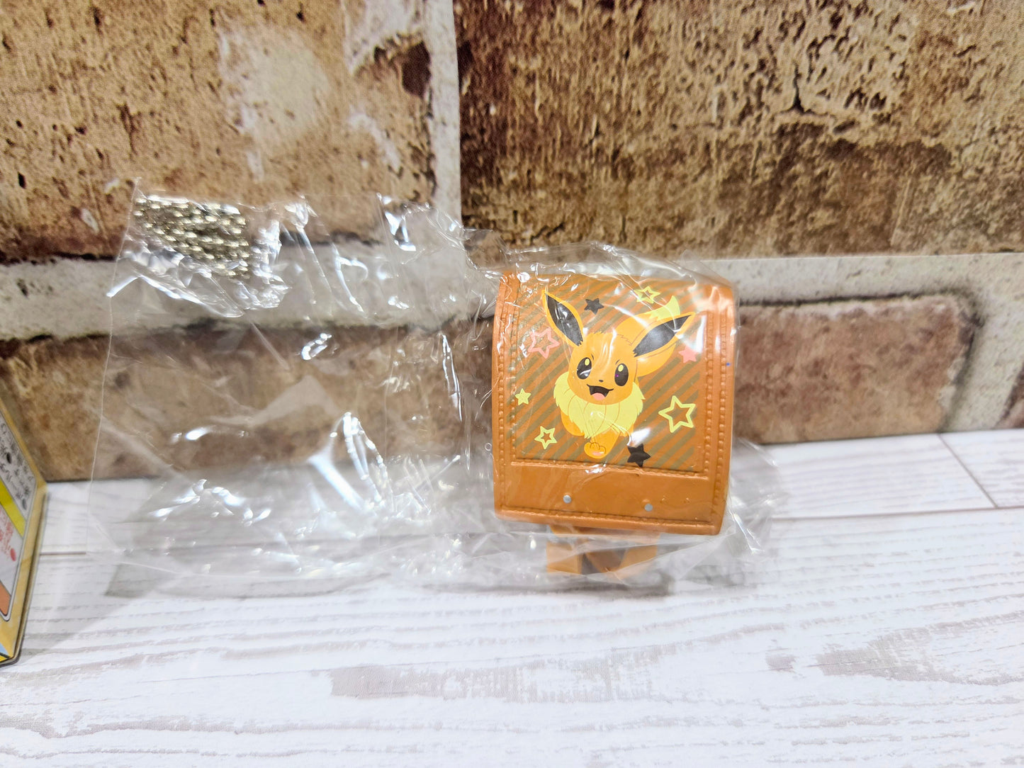 Close-up orange mini school bag figure with Eevee face and star accents