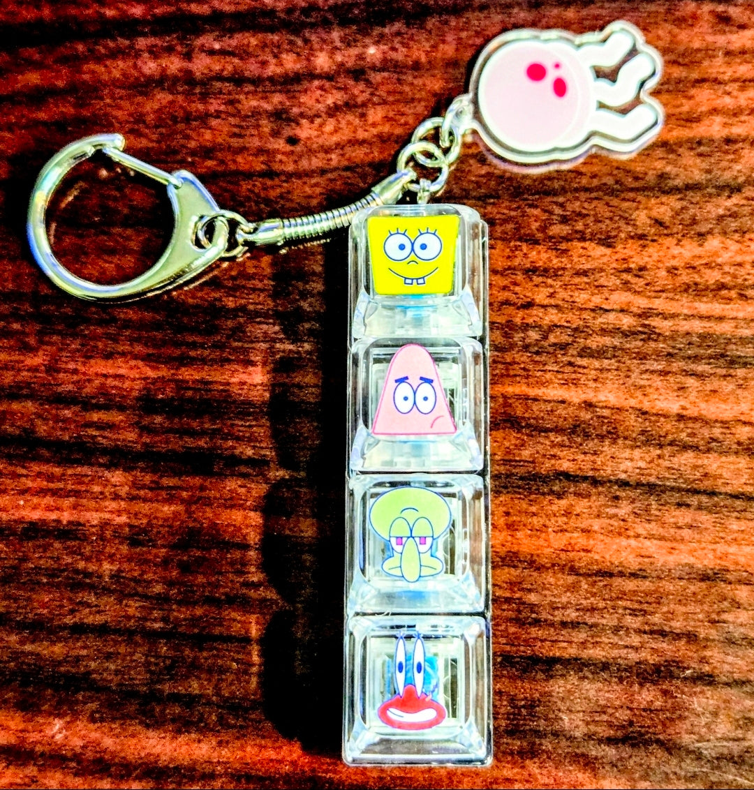 Clear acrylic keyboard fidget keychain with SpongeBob faces and hand-shaped charm
