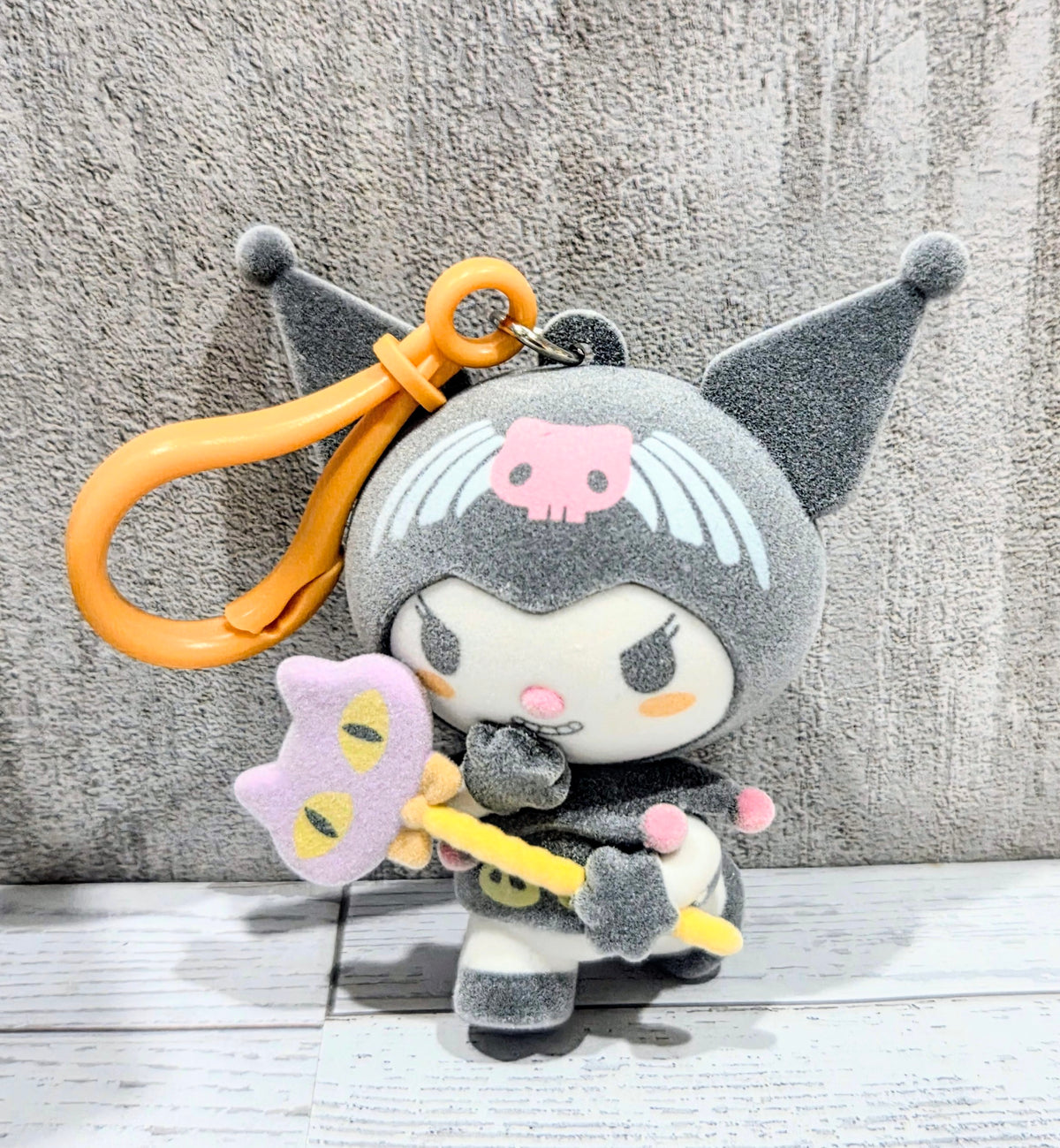 Kuromi plush bag clip with orange loop, holding star and candy-colored accents