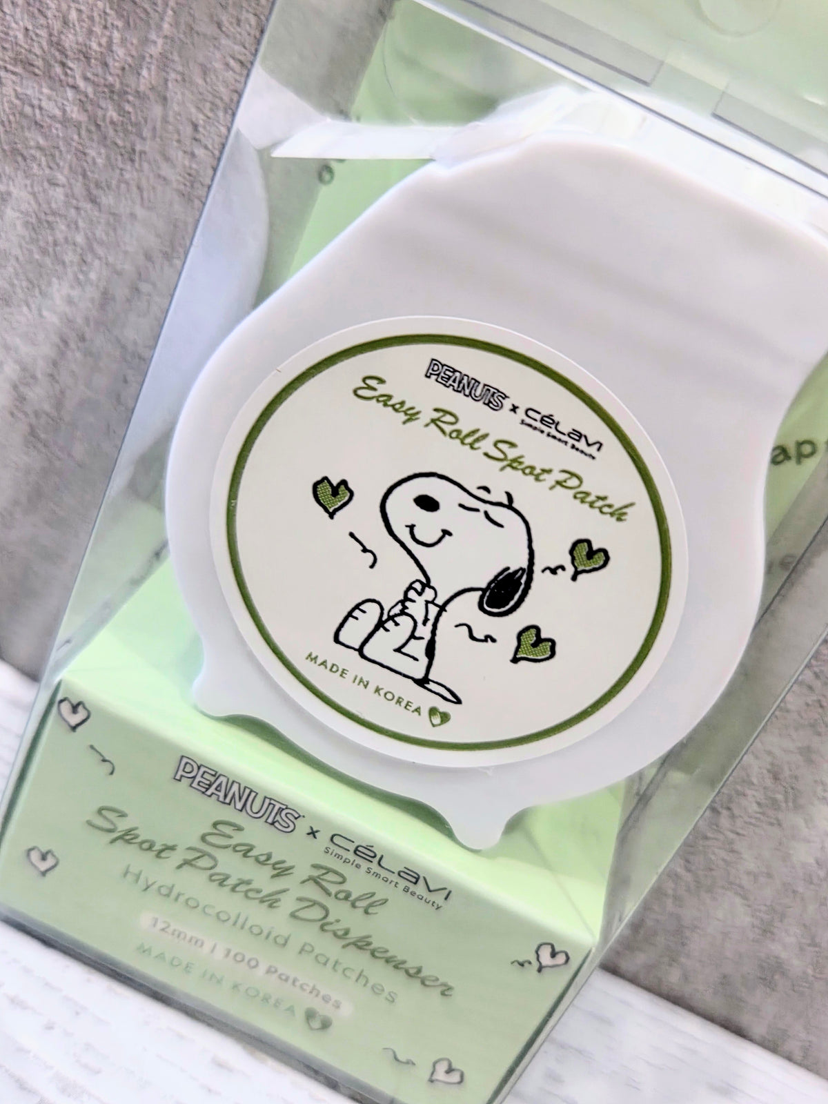 Peanuts x Celavi Easy Roll Spot Patch Dispenser with white Snoopy graphic and lime box