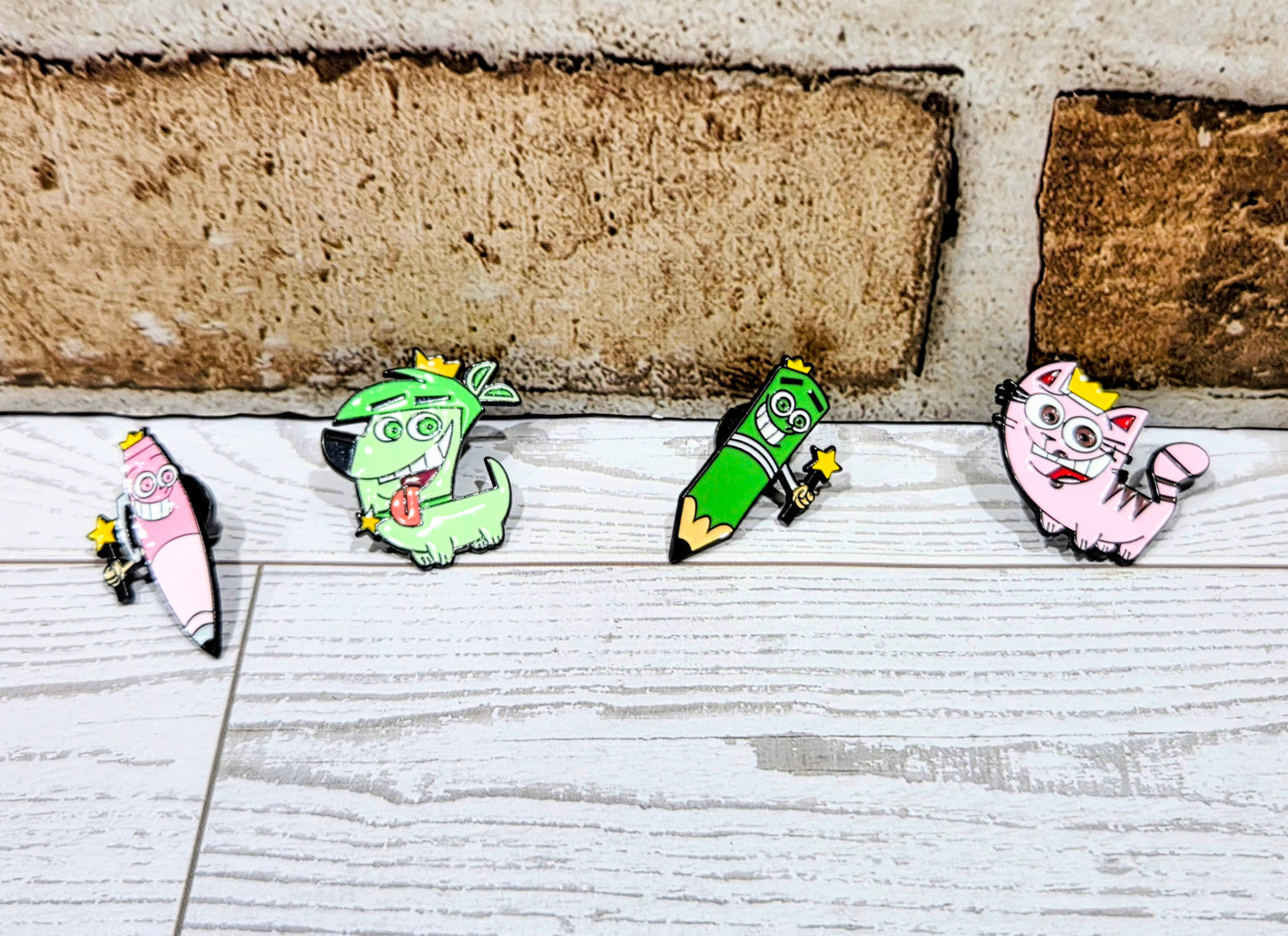 Enamel character pins set laid out on a light surface, four designs visible