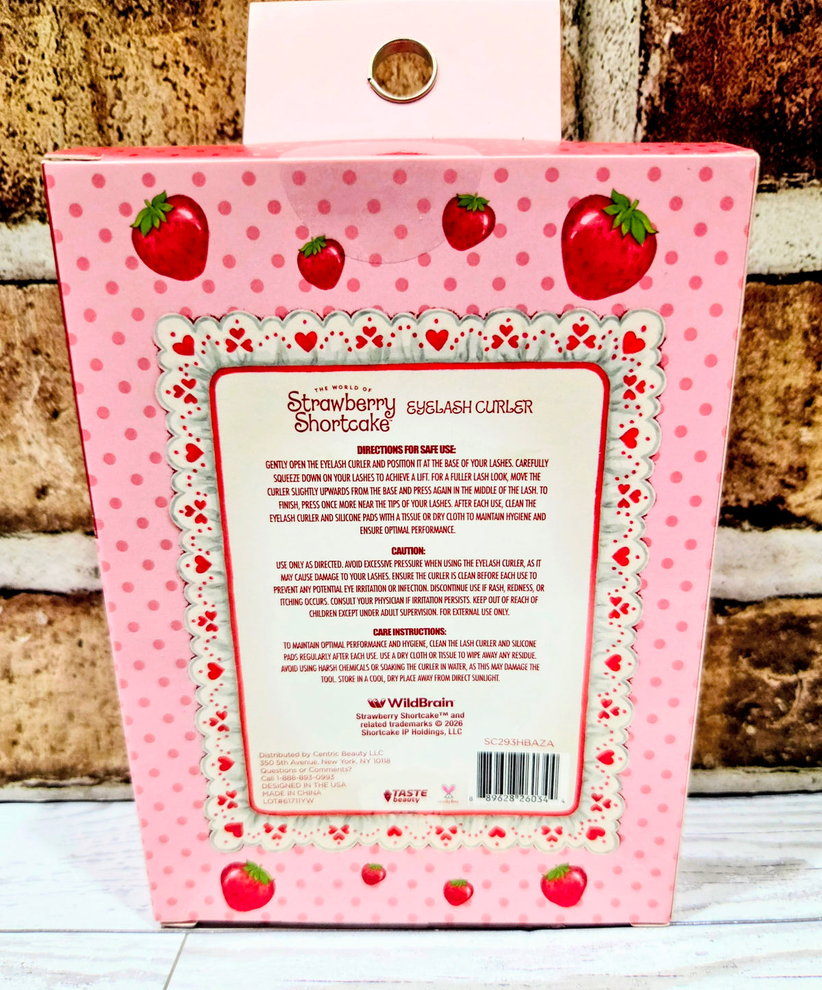 Strawberry-themed eyelash curler retail box back panel with barcode and text