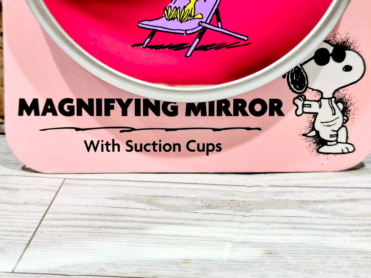 Pink magnifying mirror with suction cups, Snoopy holding sign graphic