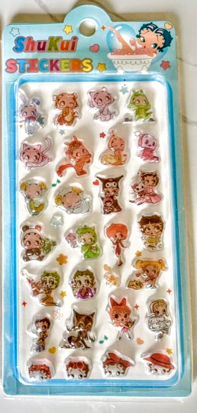 Cartoon character sticker sheet with silver-foil accents, on blue backing card