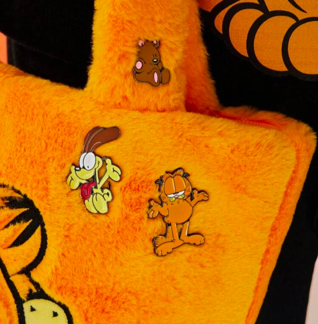 Two enamel character pins on orange plush: yellow dog and brown bear