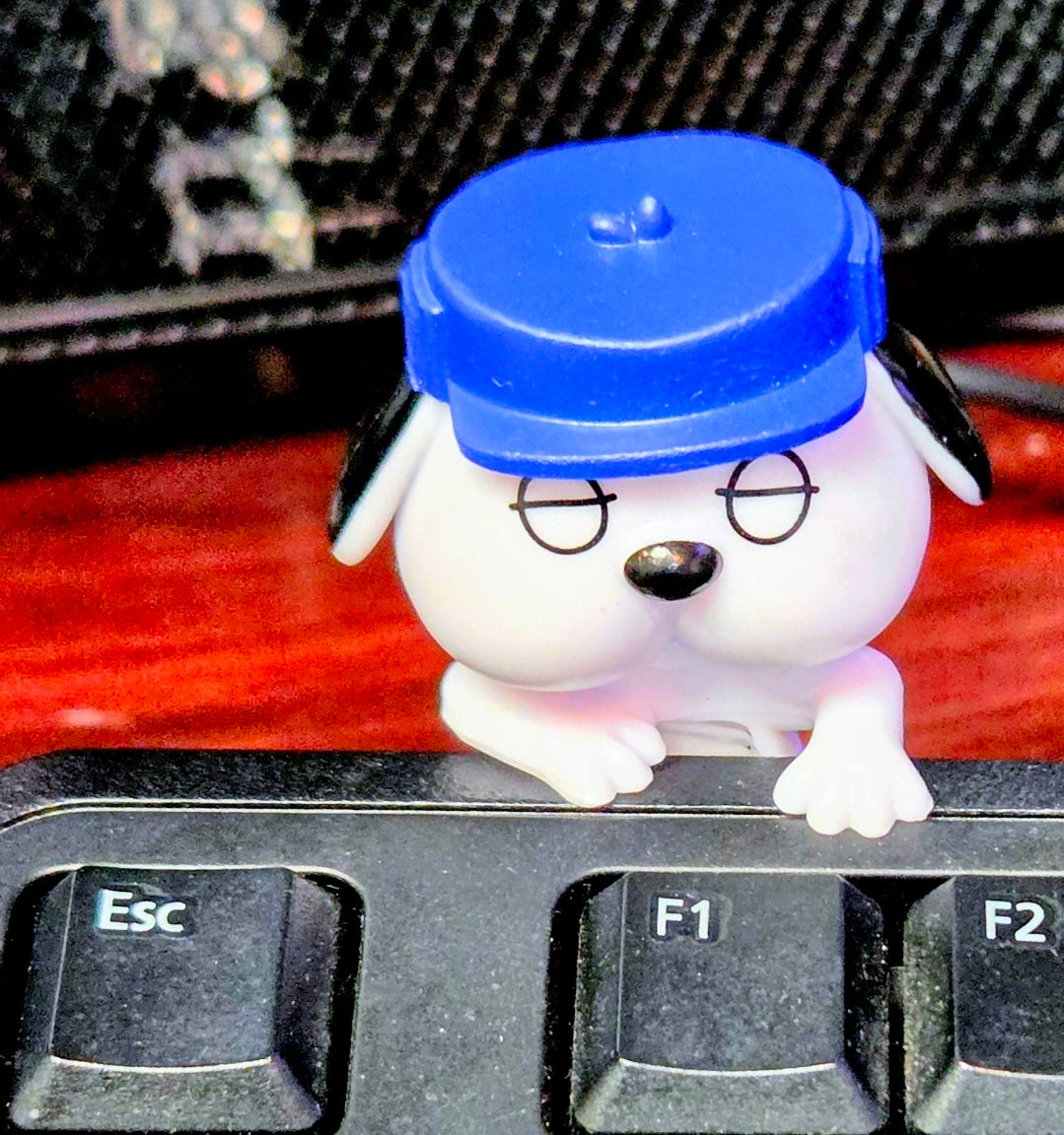 Blue-capped Olaf mini clip-on sleeping figure on keyboard with hands near torso