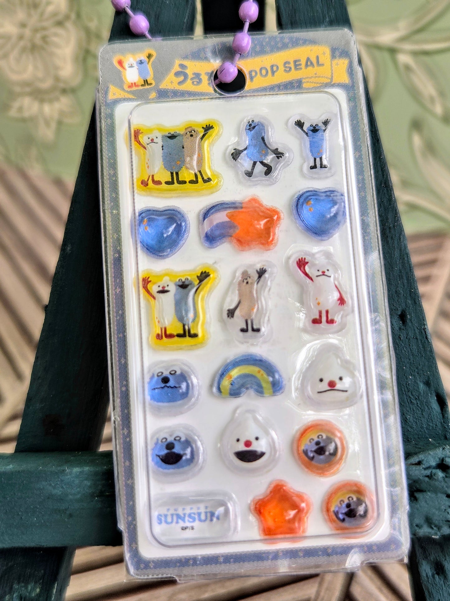 Front view of clear blister sticker keychain pack with colorful animal icons and beads