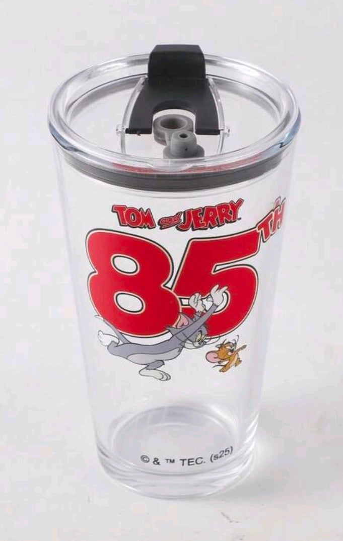 Clear tumbler lid close-up with black straw holder and Tom & Jerry 85 graphic