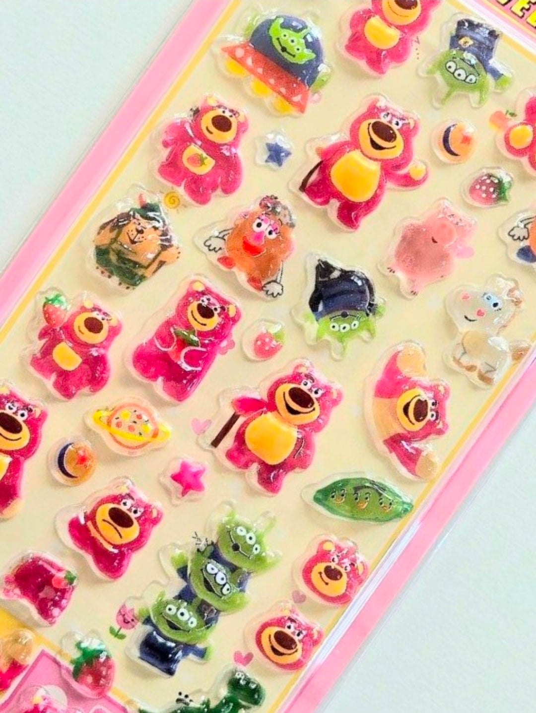 Close-up of 3D acrylic sticker sheet corner with colorful cartoon characters and aliens