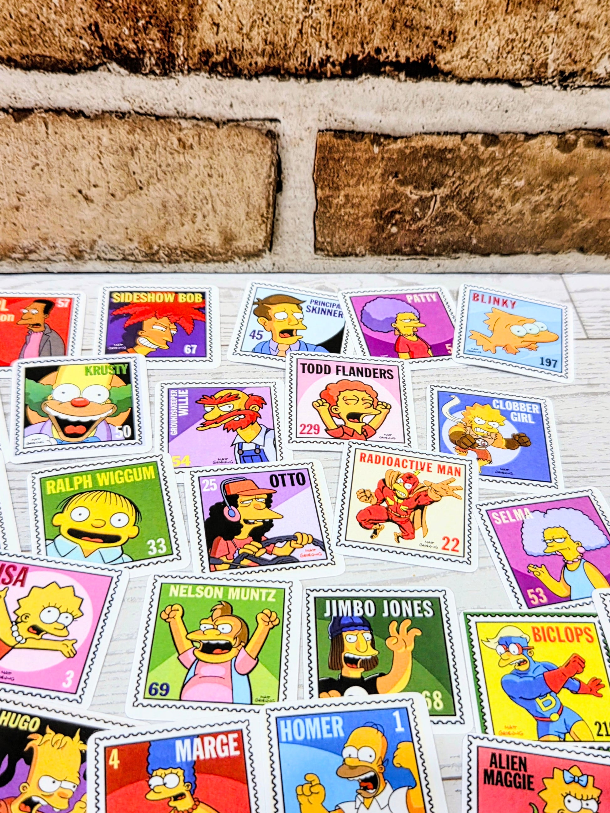 Row of Simpsons postage-stamp style stickers with character heads and symbols, colorful stamps