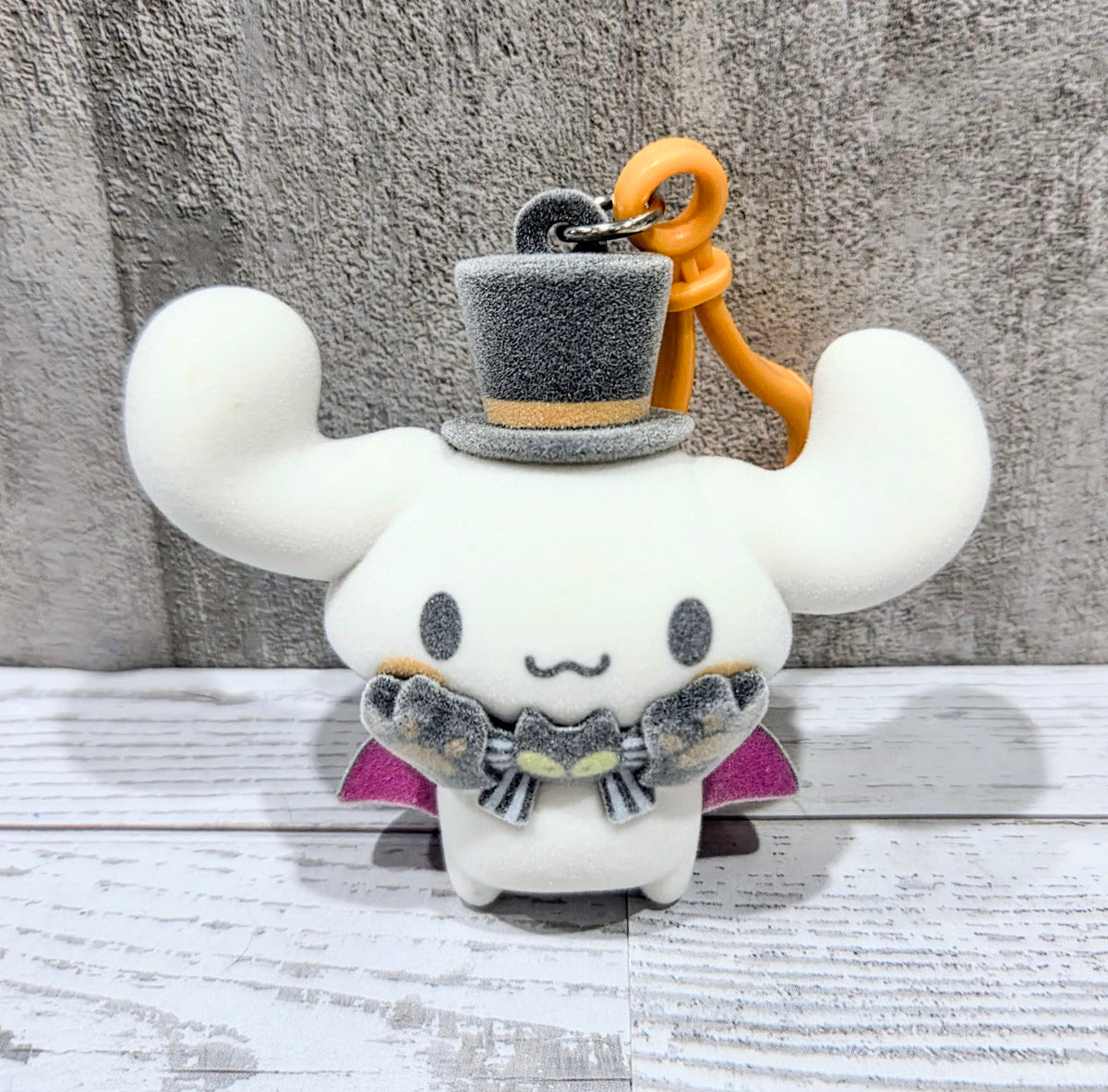 Flocked Cinnamoroll bag clip facing forward with orange loop and gray top hat