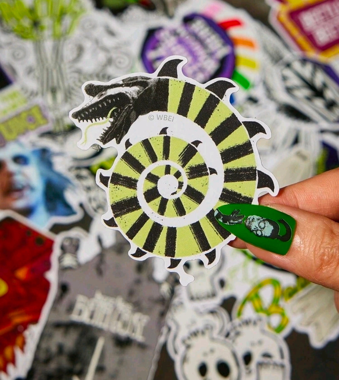 Glowing striped Beetlejuice-style monster sticker held in hand