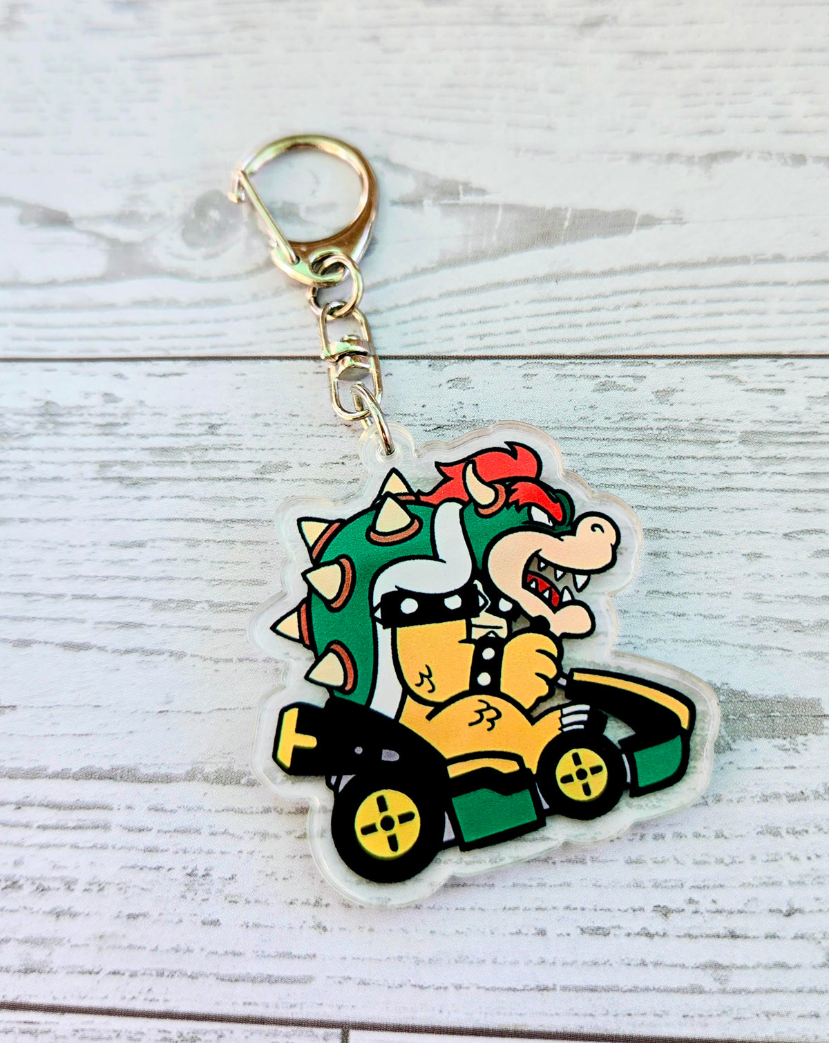 Bowser acrylic keychain charm in a green racing kart, die-cut outline