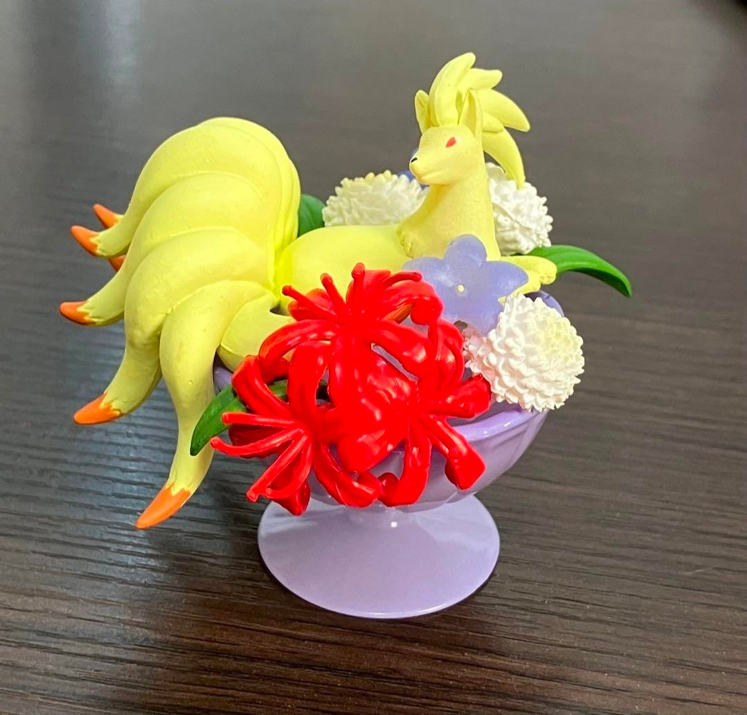 Lavender cup mini figure with yellow cat and red, white, and green flower arrangement