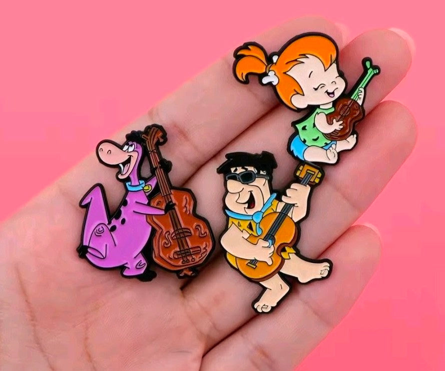 3-piece enamel pin set: Fred, Pebbles, and Dino playing instruments